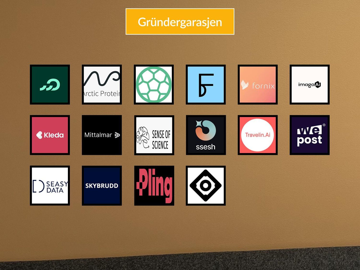 A wall of framed member company logos under a Gr&uuml;ndergarasjen sign.